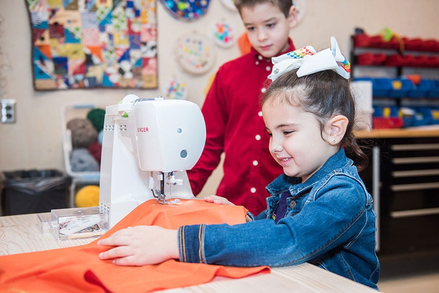 children learning how to sew