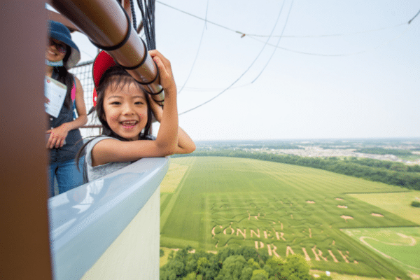 Smiling Girl On A Balloon Ride Above The Corn Maze