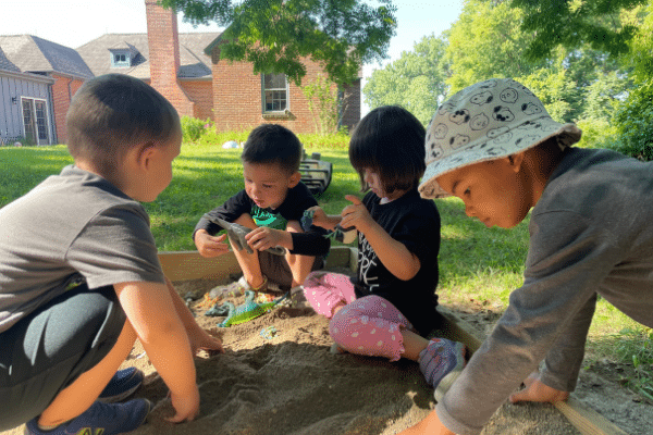 Preschool Students Playing In Sandbox