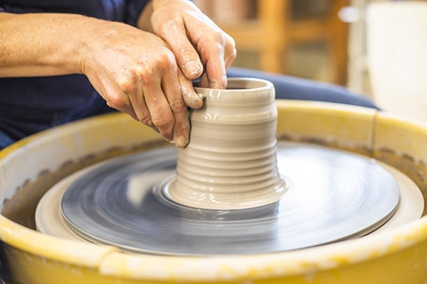Person working on pottery Person working on pottery