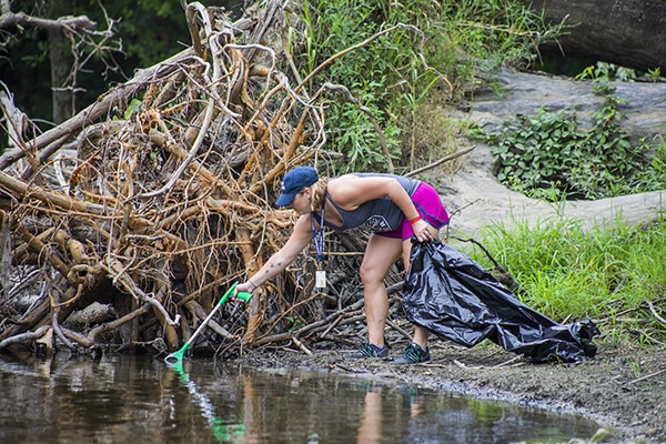 Image of an employee cleaning up the white river