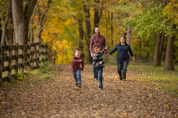 family of four on nature walk in fall