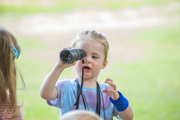 child playing with telescope at playtime on the prairie