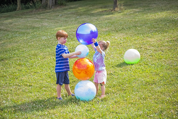 two children playing with balls at playtime on the prairie