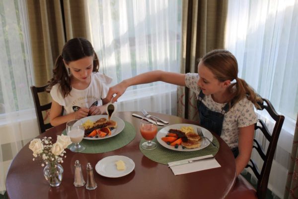 Two girls eating breakfast at the prairie guest house