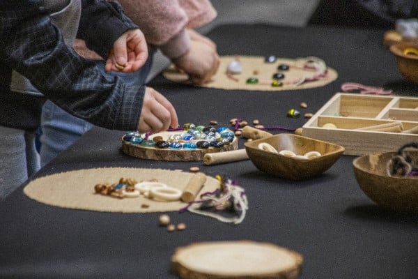 Children's hands playing with beads and other craft materials