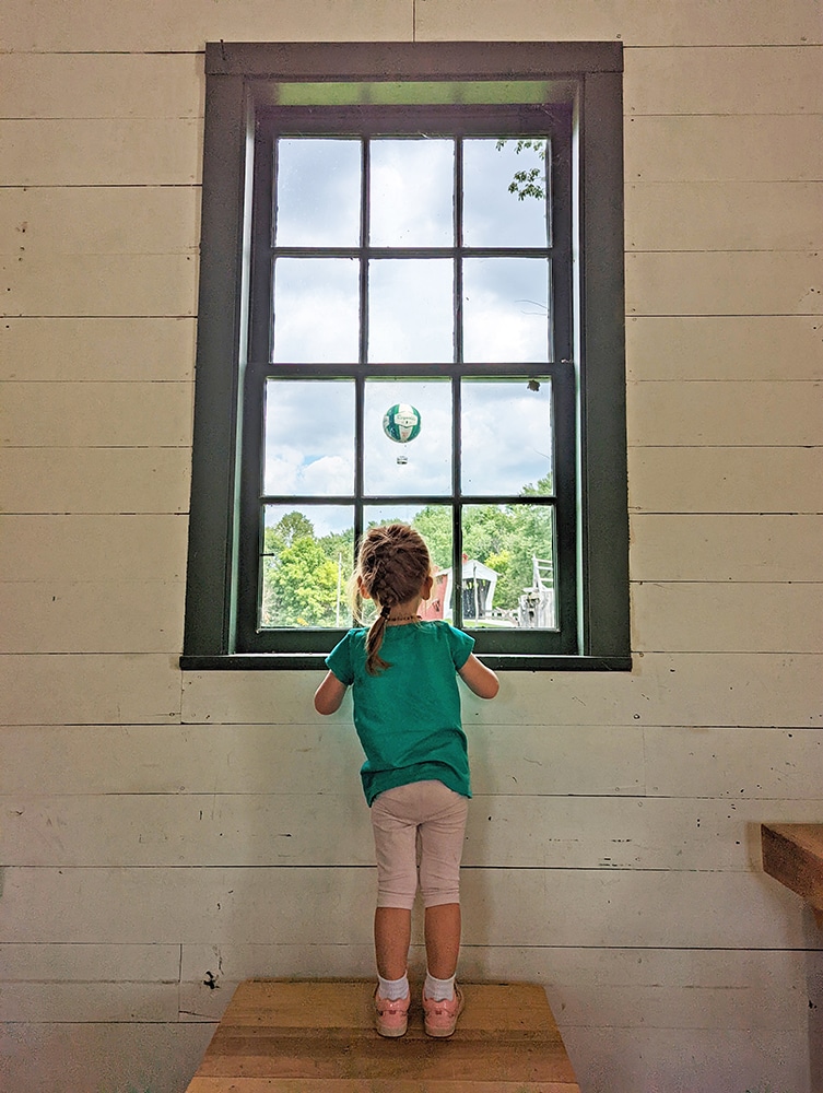 Child looking out a window at Balloon Voyage