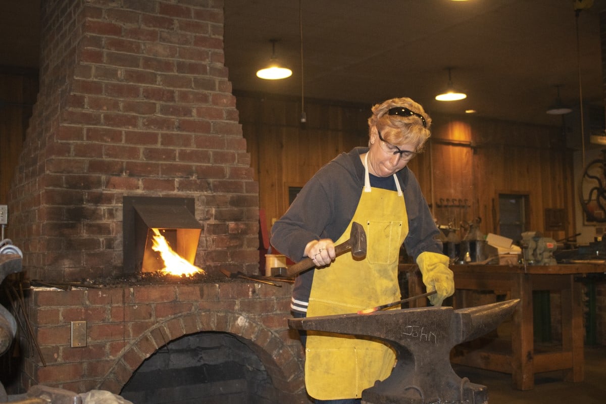 woman hitting metal on an anvil
