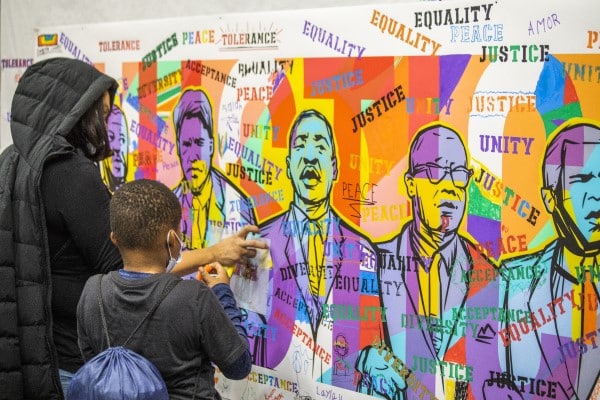 A family adding to the MLK Day mural