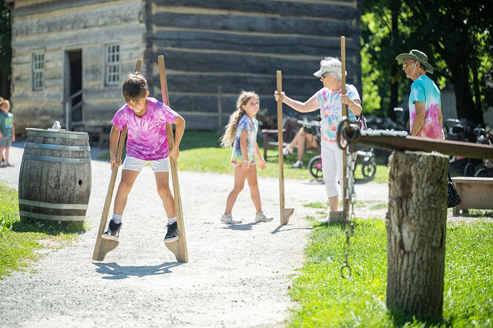 Child walking on stilts in Prairietown