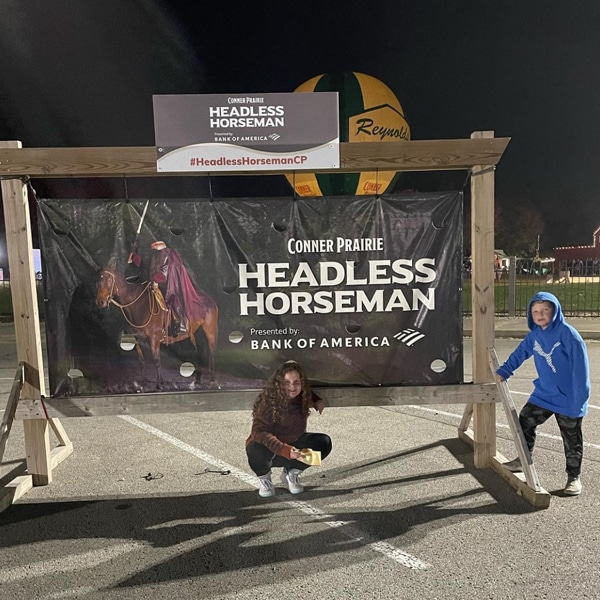 Two kids at Headless horseman with Balloon Voyage in background