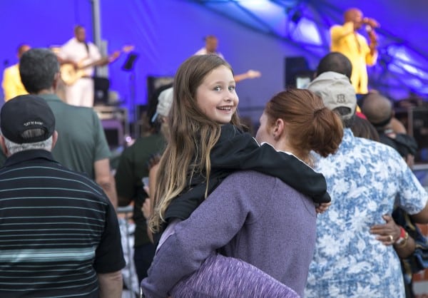 Child with their mother enjoying Symphony on the prairie