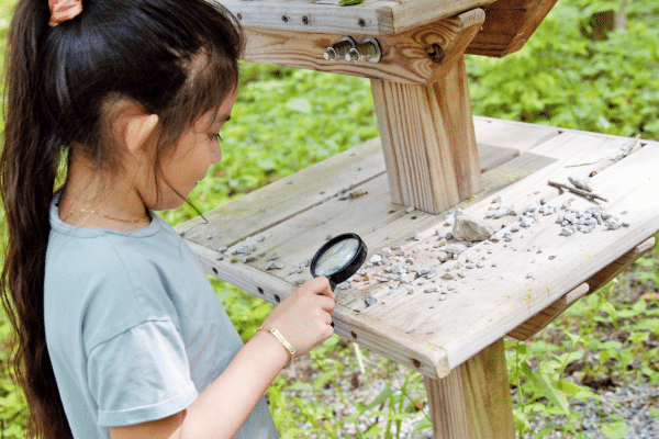 Child exploring nature with a magnifying glass