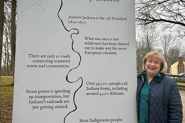 Sally McGuffey standing next to the Prairietown entrance sign