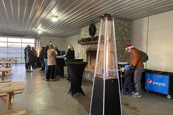 people standing at tables in front of a fireplace