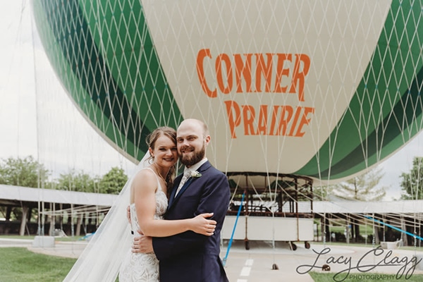 Bride and groom standing in front of balloon