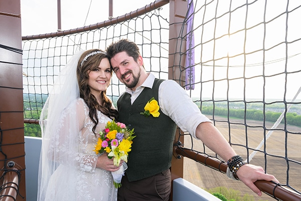 bride and groom standing in balloon gondola