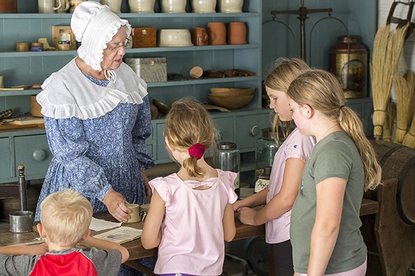 Prairietown citizen showing off store items to guests.