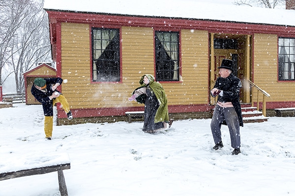 Three Prairietown residents having a snowball fight during Winter on the Prairie.