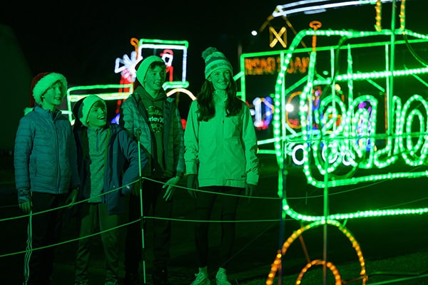 Four guests enjoying the Reynolds light display at A Merry Prairie Holiday.